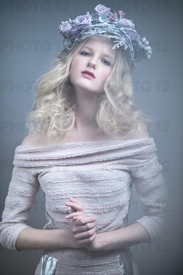 Girl with flowers on her head in a dress in the Russian style. Picture taken in the studio