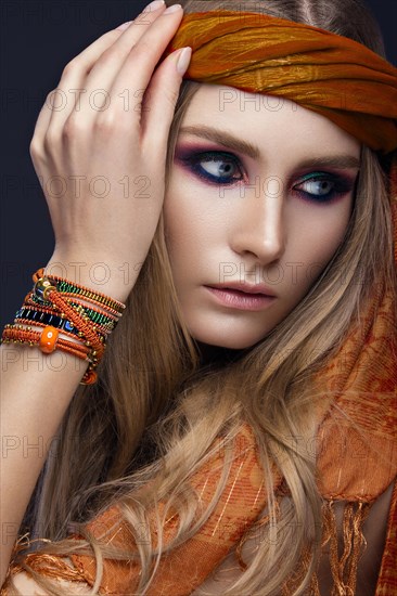 Beautiful fashion girl in a scarf and bracelets boho style. Beauty face