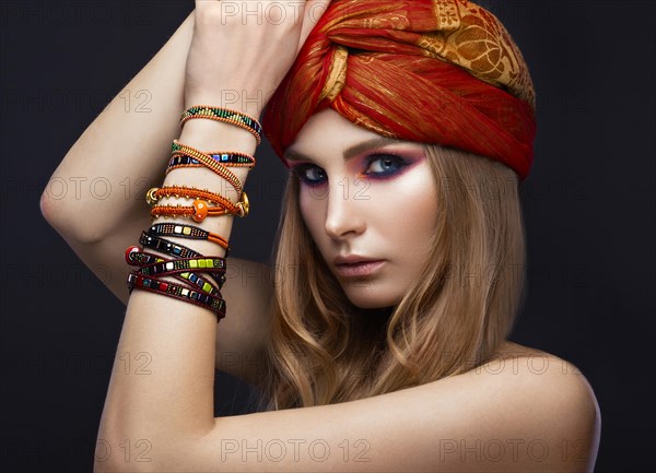 Beautiful fashion girl in a scarf and bracelets boho style. Beauty face