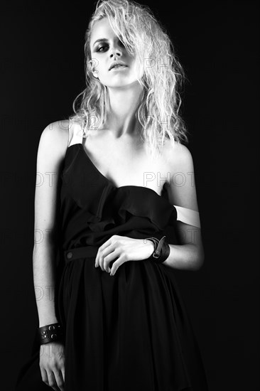 Daring girl model in black silk dress in the style of rock