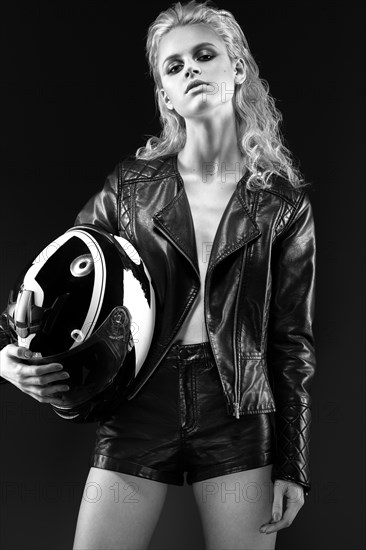 Daring girl model in black leather dress in the style of a rock on a naked body