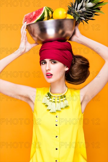 Beautiful fashionable woman an unusual hairstyle in bright clothes and colorful accessories. Cuban style. Picture taken in the studio on a bright background