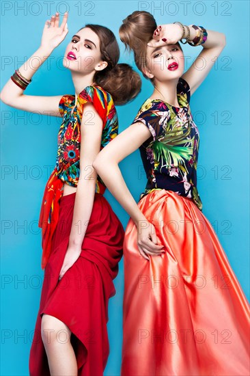 Beautiful fashionable women an unusual hairstyle in bright clothes and colorful accessories. Cuban style. Picture taken in the studio on a bright background