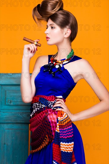 Beautiful fashionable woman an unusual hairstyle in bright clothes and colorful accessories. Cuban style. Picture taken in the studio on a bright background