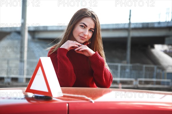 Young beautiful happy woman posing near training car