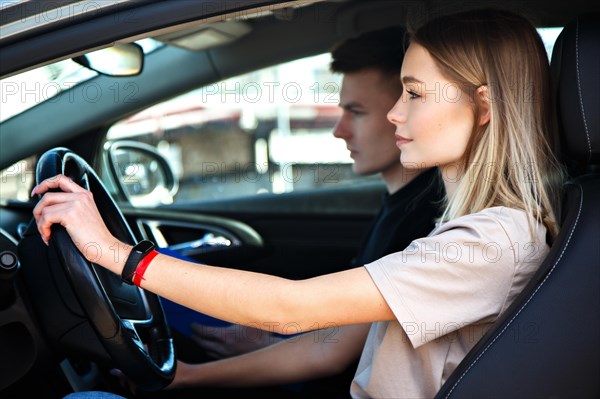 The driver is an auto school instructor and a female student on an examination car. Lesson at the circuit