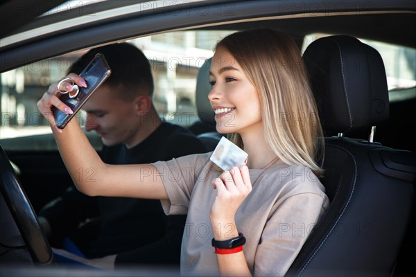 Happy smiling girl takes a selfie with a new drivers license