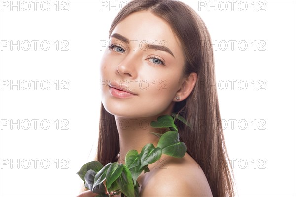 Beautiful young girl with a light natural make-up and perfect skin with Green branch in her hand. Beauty face. Picture taken in the studio on a white background