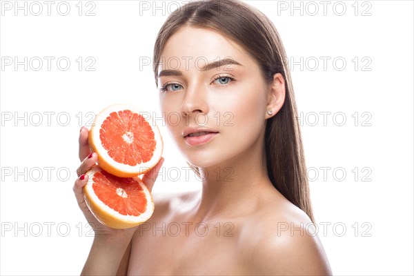 Beautiful young girl with a light natural make-up and perfect skin with Grapefruit in her hand. Beauty face. Picture taken in the studio on a white background