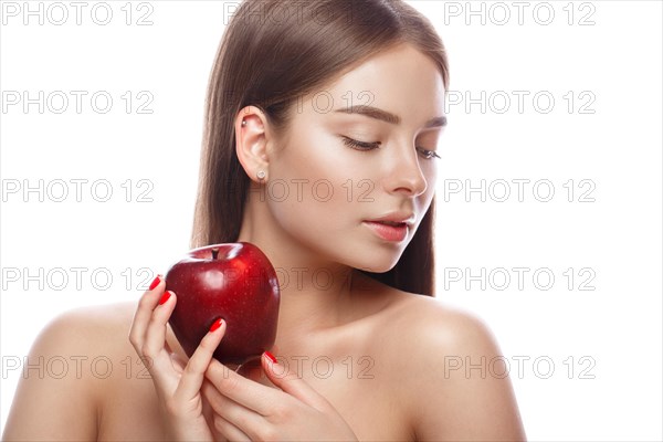 Beautiful young girl with a light natural make-up and perfect skin with apple in her hand. Beauty face. Picture taken in the studio on a white background