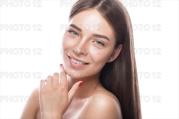 Beautiful young girl with a light natural make-up and perfect skin. Beauty face. Picture taken in the studio on a white background