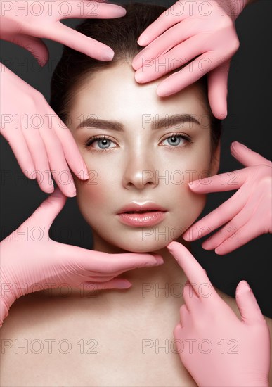 Beautiful young girl with natural nude make-up with cosmetic tools in hands. Beauty face. Photo taken in studio