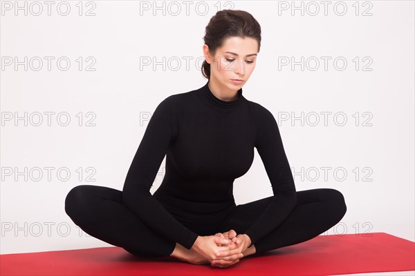 Beautiful athletic girl in black suit doing yoga asanas. Isolated on white background