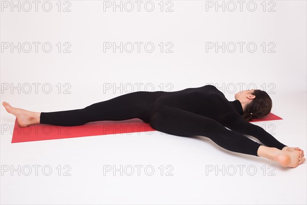 Beautiful athletic girl in black suit doing yoga asanas. Isolated on white background