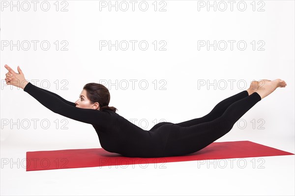 Beautiful athletic girl in black suit doing yoga. viparita naukasana asana boat pose. Isolated on white background