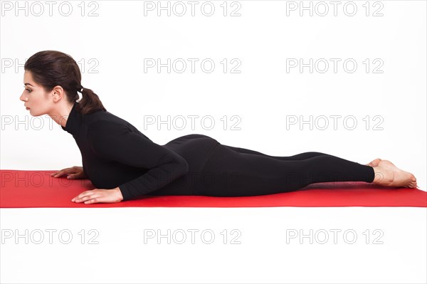 Beautiful athletic girl in a black suit doing yoga. bhujangasana asana