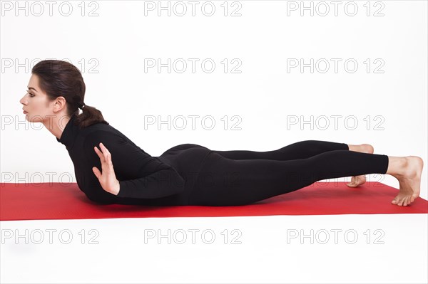 Beautiful athletic girl in a black suit doing yoga. makarasana asana
