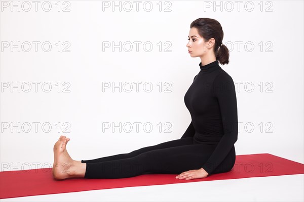 Beautiful athletic girl in a black suit doing yoga. dandasana asana