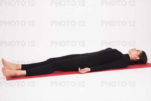 Beautiful athletic girl in black suit doing yoga asanas. Isolated on white background