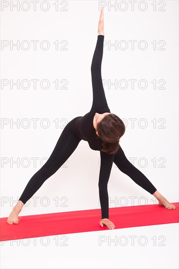 Beautiful athletic girl in black suit doing yoga asanas. Isolated on white background