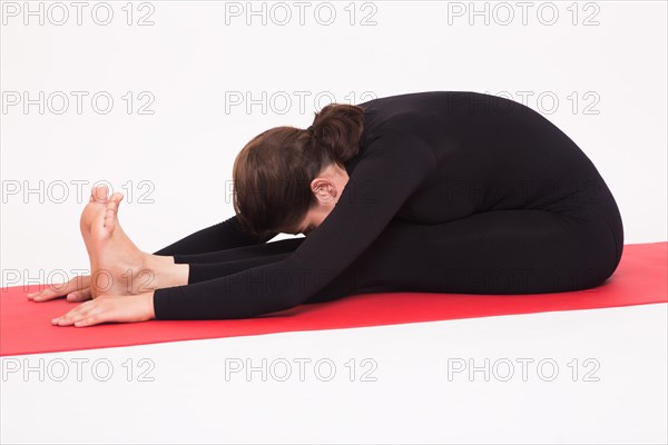 Beautiful athletic girl in black suit doing yoga asanas. Isolated on white background