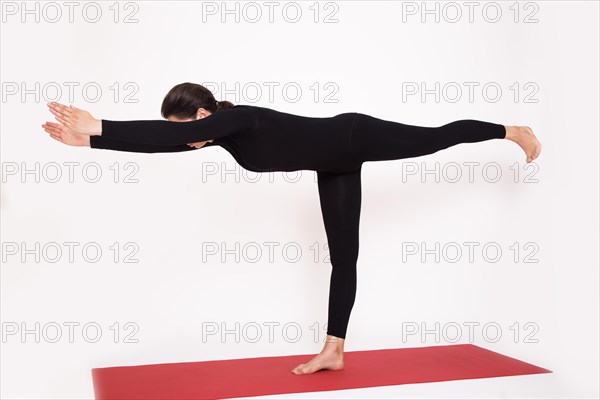 Beautiful athletic girl in a black suit doing yoga. Virabkhadrasana asana