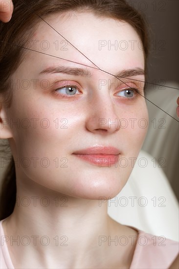 Permanent microblasting tattooing freckles to a woman in a beauty salon