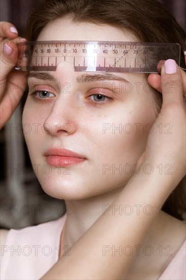 Permanent microblasting tattooing freckles to a woman in a beauty salon