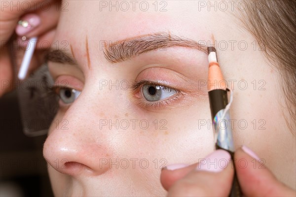 Permanent microblasting tattooing freckles to a woman in a beauty salon