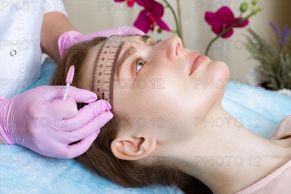 Permanent microblasting tattooing freckles to a woman in a beauty salon