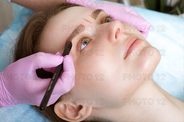 Permanent microblasting tattooing freckles to a woman in a beauty salon