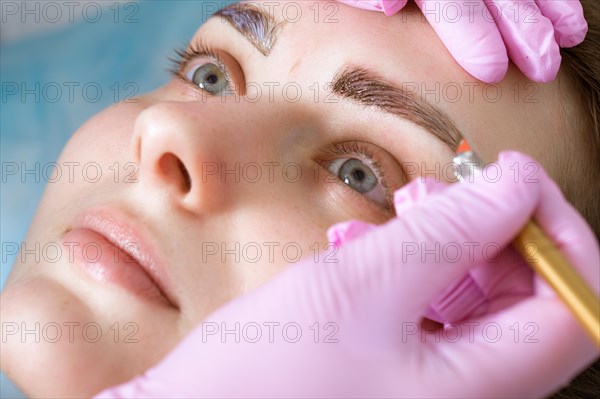 Permanent microblasting tattooing freckles to a woman in a beauty salon