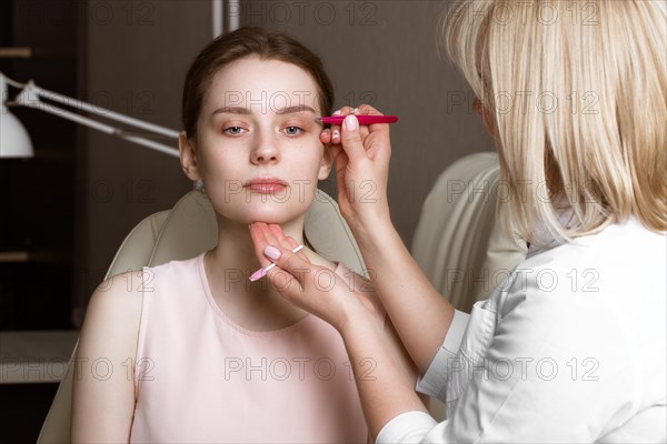 Permanent microblasting tattooing freckles to a woman in a beauty salon