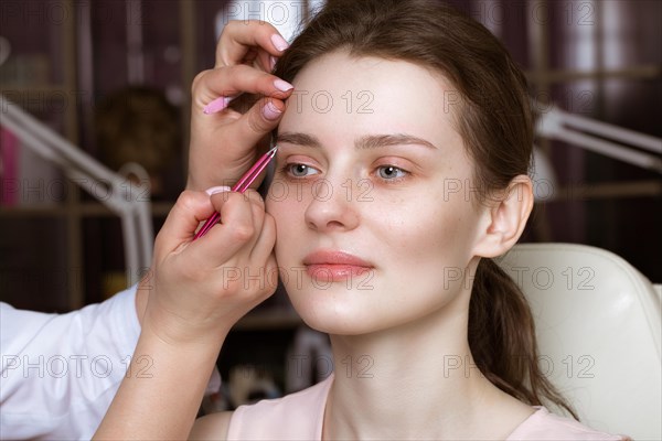 Permanent microblasting tattooing freckles to a woman in a beauty salon