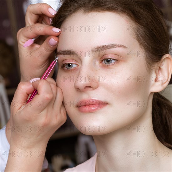 Permanent microblasting tattooing freckles to a woman in a beauty salon