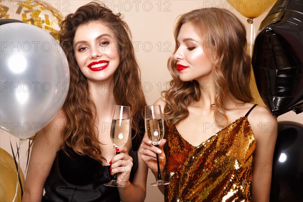 Beautiful young women in elegant evening dresses with festive balloons. Beauty face. Photo taken in the studio