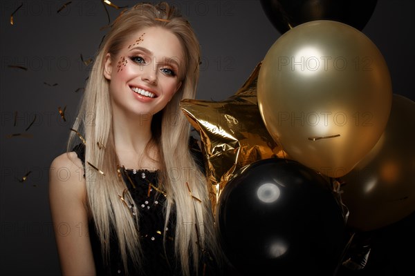 Beautiful young girl in elegant evening dress with festive balloons. Beauty face. Photo taken in the studio
