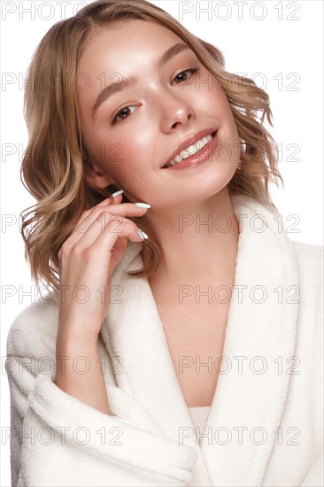 Beautiful tender young girl in a white coat with clean fresh skin posing in front of the camera. Beauty face. Skin care. Photo taken in studio on a white isolate background