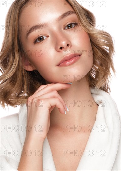 Beautiful tender young girl in a white coat with clean fresh skin posing in front of the camera. Beauty face. Skin care. Photo taken in studio on a white isolate background