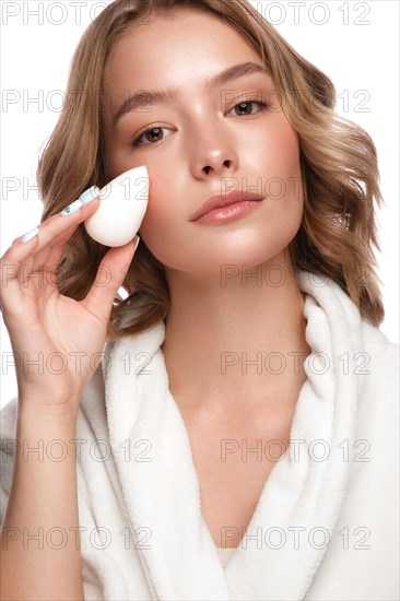 Beautiful tender young girl in a white coat with clean fresh skin posing in front of the camera. Beauty face. Skin care. Photo taken in studio on a white isolate background