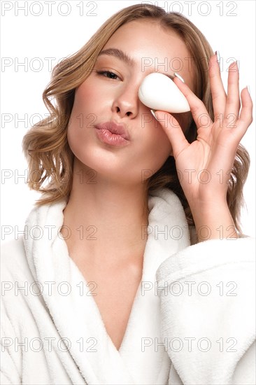 Beautiful tender young girl in a white coat with clean fresh skin posing in front of the camera. Beauty face. Skin care. Photo taken in studio on a white isolate background