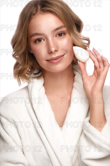 Beautiful tender young girl in a white coat with clean fresh skin posing in front of the camera. Beauty face. Skin care. Photo taken in studio on a white isolate background