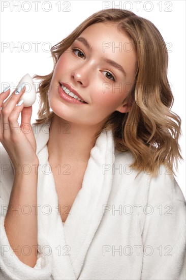 Beautiful tender young girl in a white coat with clean fresh skin posing in front of the camera. Beauty face. Skin care. Photo taken in studio on a white isolate background