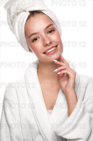 Beautiful tender young girl in a white towel with clean fresh skin posing in front of the camera. Beauty face. Skin care. Photo taken in studio on a white isolate background