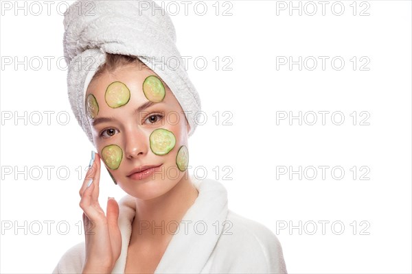 Beautiful tender young girl in a white towel with clean fresh skin posing in front of the camera. Beauty face. Skin care. Photo taken in studio on a white isolate background