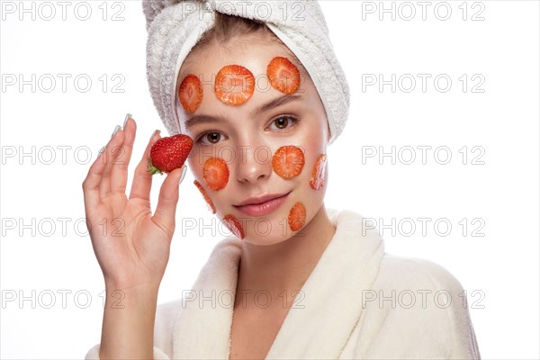 Beautiful tender young girl in a white towel with clean fresh skin posing in front of the camera. Beauty face. Skin care. Photo taken in studio on a white isolate background