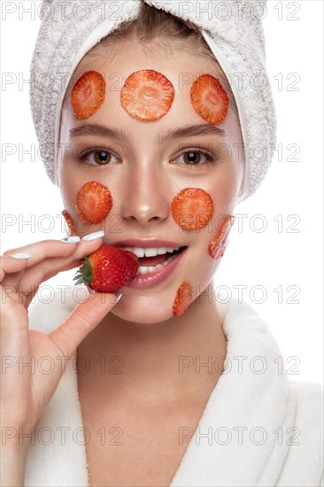 Beautiful tender young girl in a white towel with clean fresh skin posing in front of the camera. Beauty face. Skin care. Photo taken in studio on a white isolate background