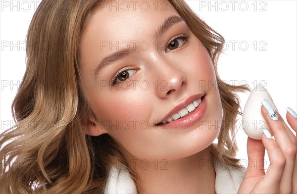 Beautiful tender young girl in a white coat with clean fresh skin posing in front of the camera. Beauty face. Skin care. Photo taken in studio on a white isolate background