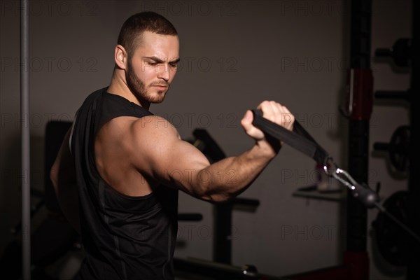 Sporty sexy men with great abdominal muscles in black sportswear working out in the gym