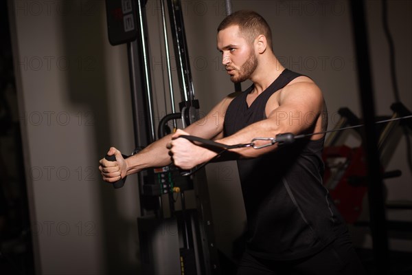 Sporty sexy men with great abdominal muscles in black sportswear working out in the gym